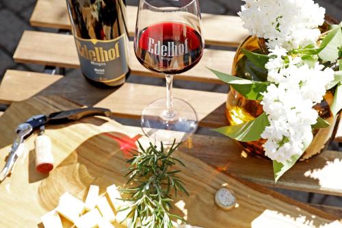 a wooden table with a bottle of wine and a wine glass at WeinQuartier Minges in Kirrweiler