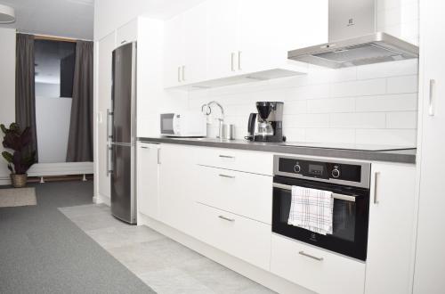 a kitchen with white cabinets and a stove top oven at Apartments Malmö in Malmö