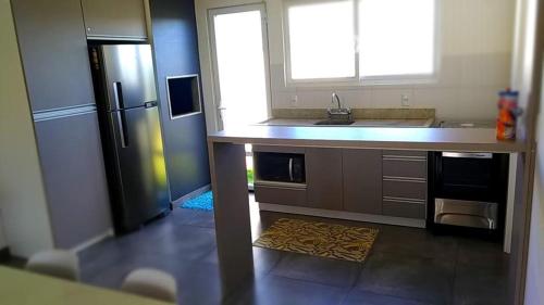 uma cozinha com um lavatório e um frigorífico em CASA EM CONDOMÍNIO - 3 dormitórios - LAZER COMPLETO - Xangri-lá em Xangri-lá