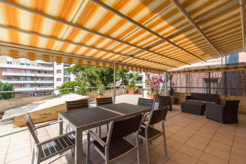 un patio avec une pergola en bois et une table et des chaises dans l'établissement Appartement grande terrasse à coté Monaco & plage, à Saint-Antoine
