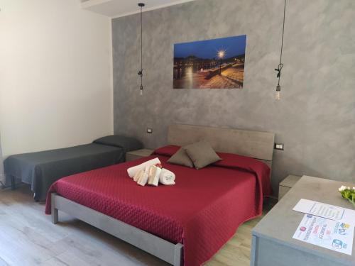 a bedroom with a red bed with a stuffed animal on it at R&B mediterraneo in Bosa