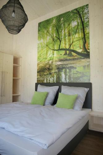 a bedroom with a bed with a painting on the wall at Steigerwald-Apartments in Ebrach