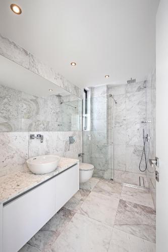 a white bathroom with two sinks and a shower at Eros Cyprus in Ayia Napa