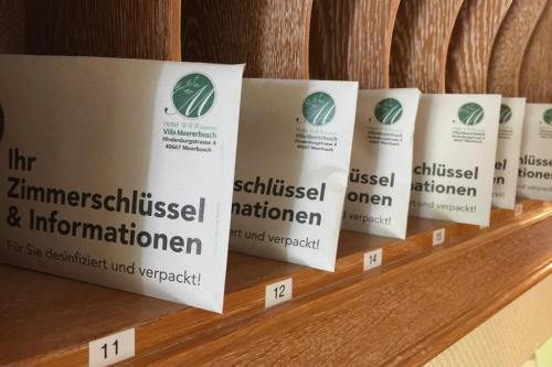 a row of signs on a wooden shelf at Hotel Villa Meererbusch in Meerbusch