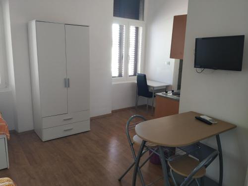 a room with a desk and a table and a cabinet at Apartments Todorovic in Pula