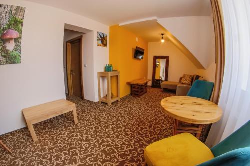 uma sala de estar com uma mesa e um sofá em Residence Rooms Bucovina em Câmpulung Moldovenesc
