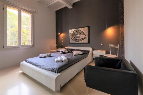 a bedroom with a bed and a chair in it at Charming Flat in centro a Ferrara con posto auto in Ferrara