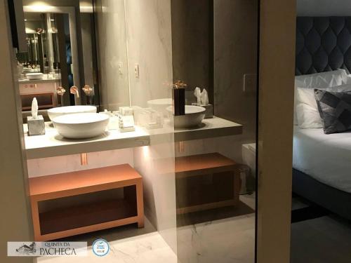 a bathroom with two sinks and a bed and a mirror at Pacheca The Wine House Hotel e Spa - Quinta da Pacheca in Lamego