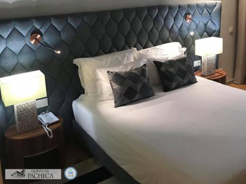 a bedroom with a bed with a headboard and a phone at Pacheca The Wine House Hotel e Spa - Quinta da Pacheca in Lamego