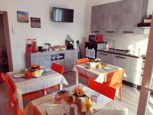 a dining room with two tables and a kitchen at R&B mediterraneo in Bosa