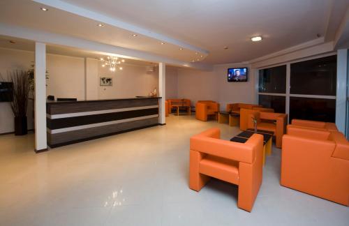 a living room filled with furniture and a tv at Hotel SPA Arkadia in Apšuciems