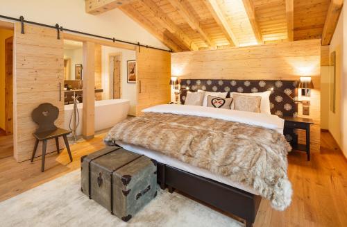 a bedroom with a large bed and a bath tub at Hotel Piz Buin Klosters in Klosters