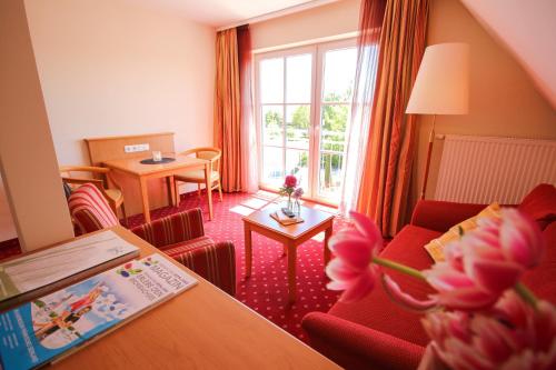 a hotel room with a red couch and a table at Cafe-Restaurant Zum Hochreiter in Spalt