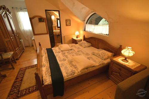 a bedroom with a large bed and a window at Casa Poveste Pensiunea-Muzeu in Câmpulung Moldovenesc