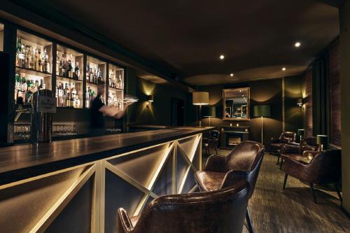 a bar with leather chairs in a room at Lounge-Hotel Seeterrassen in Wandlitz