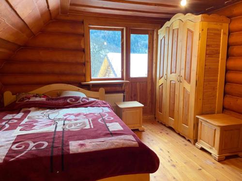 a bedroom with a bed in a log cabin at Дерев'яний котедж "Казка" in Yaremche