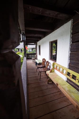 a group of benches sitting on a wooden deck at Casa Poveste Pensiunea-Muzeu in Câmpulung Moldovenesc