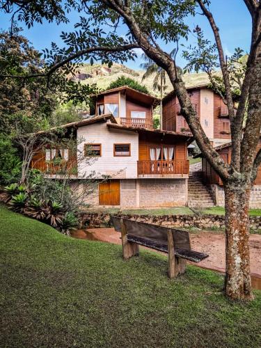 a house with a bench in front of it at Pousada Aracê in Pedra Azul