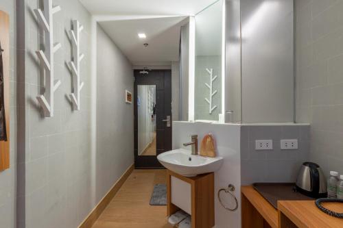 a bathroom with a sink and a mirror at Selah Pods Hotel Manila in Manila