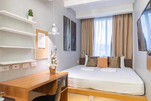a bedroom with a bed and a desk with a desk at Selah Pods Hotel Manila in Manila