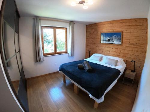 een slaapkamer met een groot bed en een televisie bij Serre Che Chalet in Briançon