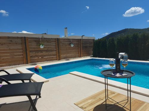 希貝尼克的住宿－Villa Belitzein with swimming pool，一个带桌子和两杯葡萄酒的游泳池