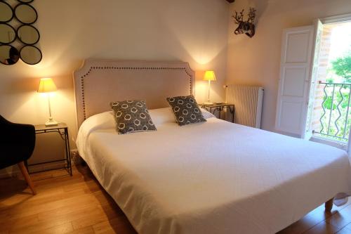 a bedroom with a white bed with two pillows on it at Le Manoir Saint Clair in Balma