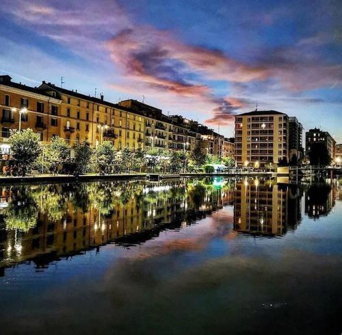 a reflection of buildings in the water in a city at Hotel La Vignetta in Milan
