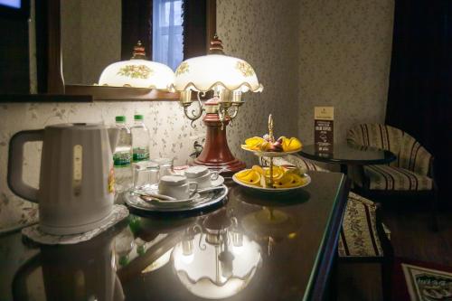 un tavolo con una lampada e un piatto di frutta sopra di Sokol Hotel a Suzdal