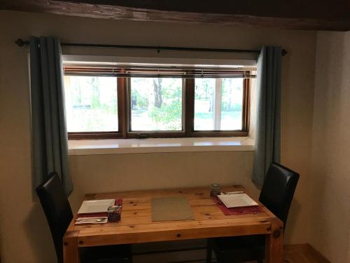 a wooden table with two chairs and a window at La Grange Country Inn in Wakefield