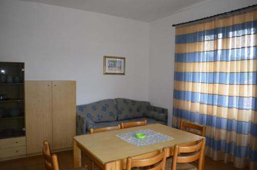 a dining room with a table and a couch at Elbamar Procchio in Procchio