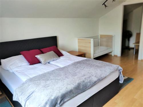 uma cama grande com almofadas vermelhas num quarto em Haus zum Wohlfühlen em Viena