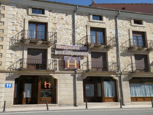 a large stone building with balconies on a street at Hotel Laberinto in Sigüenza