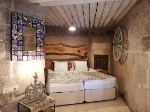 a bedroom with a bed in a stone wall at Pigeon Hotel Cappadocia in Uchisar