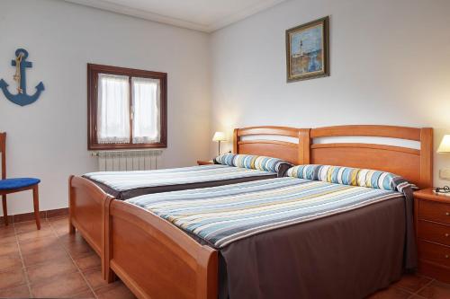 1 dormitorio con 1 cama grande de madera en una habitación en Epotx Etxea, en Getaria