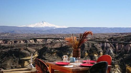a table with chairs and a mountain in the background at Pigeon Hotel Cappadocia in Uçhisar