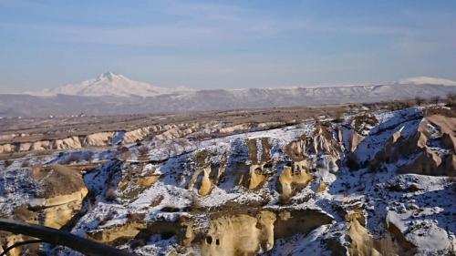 a view of a snowy mountain range with snow covered rocks at Pigeon Hotel Cappadocia in Uchisar