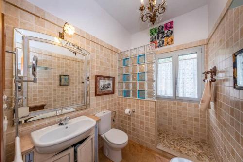 bagno con lavabo, servizi igienici e specchio di Villa Luxury a Binibeca