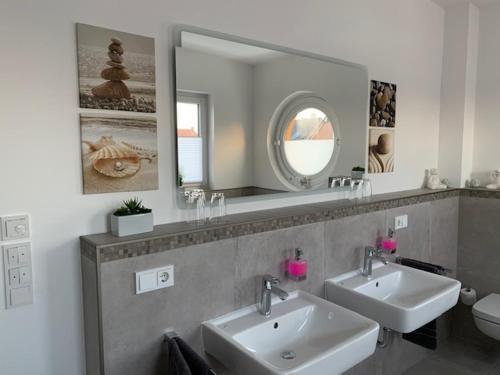 a bathroom with two sinks and a large mirror at Urban Apartement-Boardinghouse Wadersloh in Wadersloh