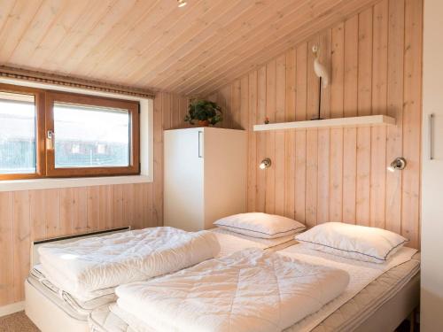 Dos camas en una habitación con paredes de madera. en 6 person holiday home in Fanø, en Fanø