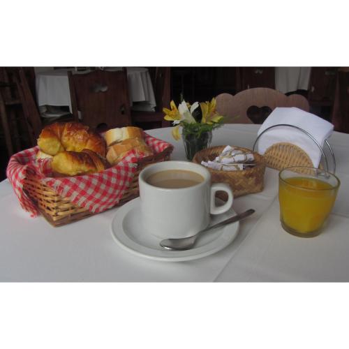 a table with a cup of coffee and a basket of bread at Hosteria Helvecia in Montecarlo