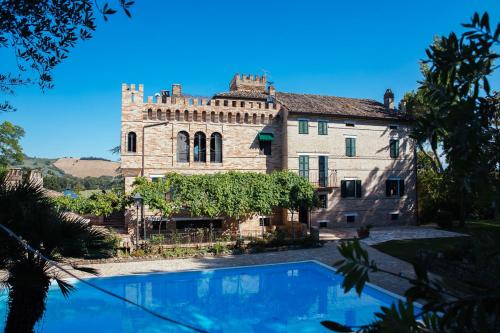 an old building with a swimming pool in front of it at Villa De Castelletta Relais in Rapagnano