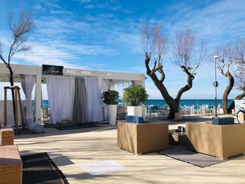 a building with chairs and trees and the ocean at Apartment Gio in Novigrad Istria