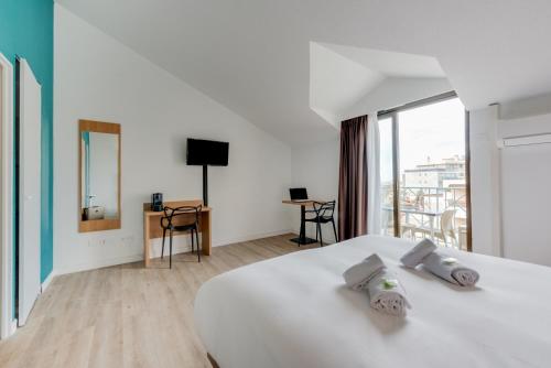 カンヌにあるレジドホテル レ コラリヌのベッドルーム(白いベッド1台、バルコニー付)