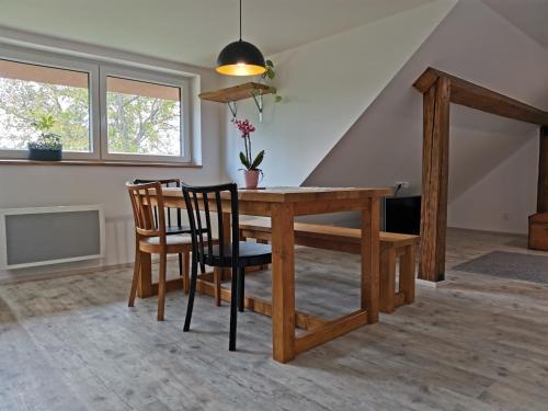 - une salle à manger avec une table et des chaises en bois dans l'établissement Apartmány Svatá, à Svatá