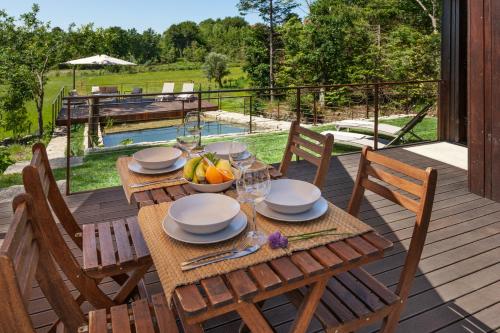 a wooden table with a bowl of fruit on a deck at Casa do Monte da Veiga - Minho's Guest in Póvoa de Lanhoso