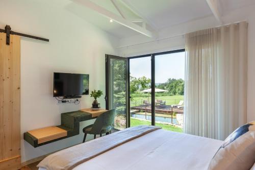 a bedroom with a bed and a desk and a television at Casa do Monte da Veiga - Minho's Guest in Póvoa de Lanhoso