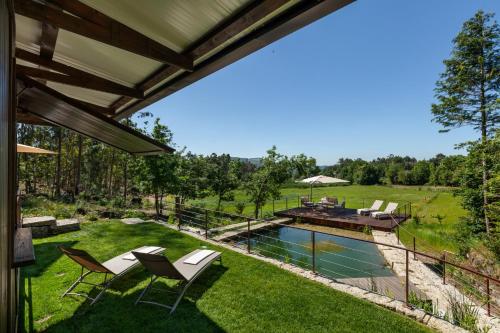 an outdoor patio with chairs and a swimming pool at Casa do Monte da Veiga - Minho's Guest in Póvoa de Lanhoso