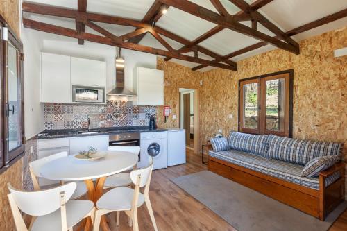 a kitchen and living room with a couch and a table at Casa do Monte da Veiga - Minho's Guest in Póvoa de Lanhoso