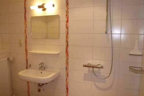 a bathroom with a sink and a shower at Waddenhoes Gastenverblijven in Pieterburen